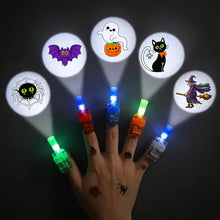 LED finger projector rings worn on a hand projecting a Halloween design