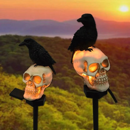 Halloween skeleton head solar light glowing in a garden