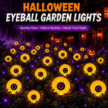 Five purple glowing eyeball solar lights staring out of garden bushes at night