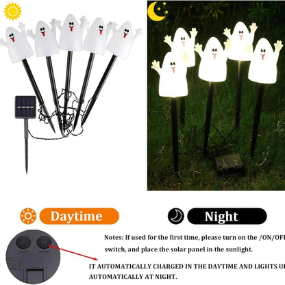 Solar Halloween lights illuminated on a lawn at dusk