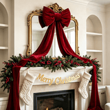 Large red fabric bow with long tassel ribbon tails hanging on a door