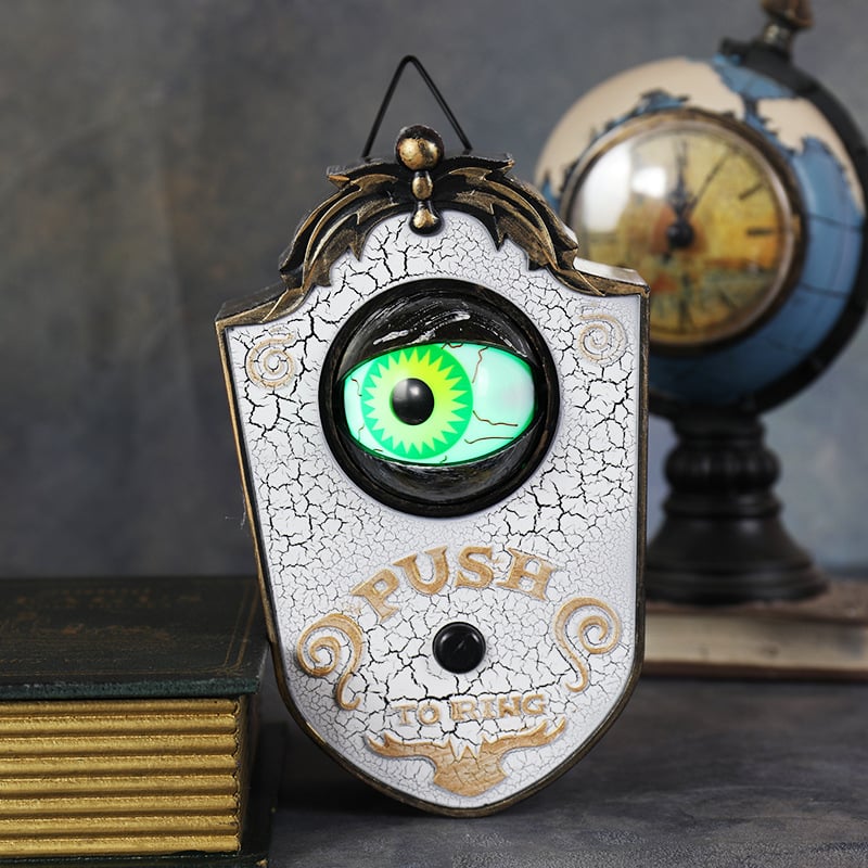 Halloween doorbell prop with a glowing eye mounted beside a door
