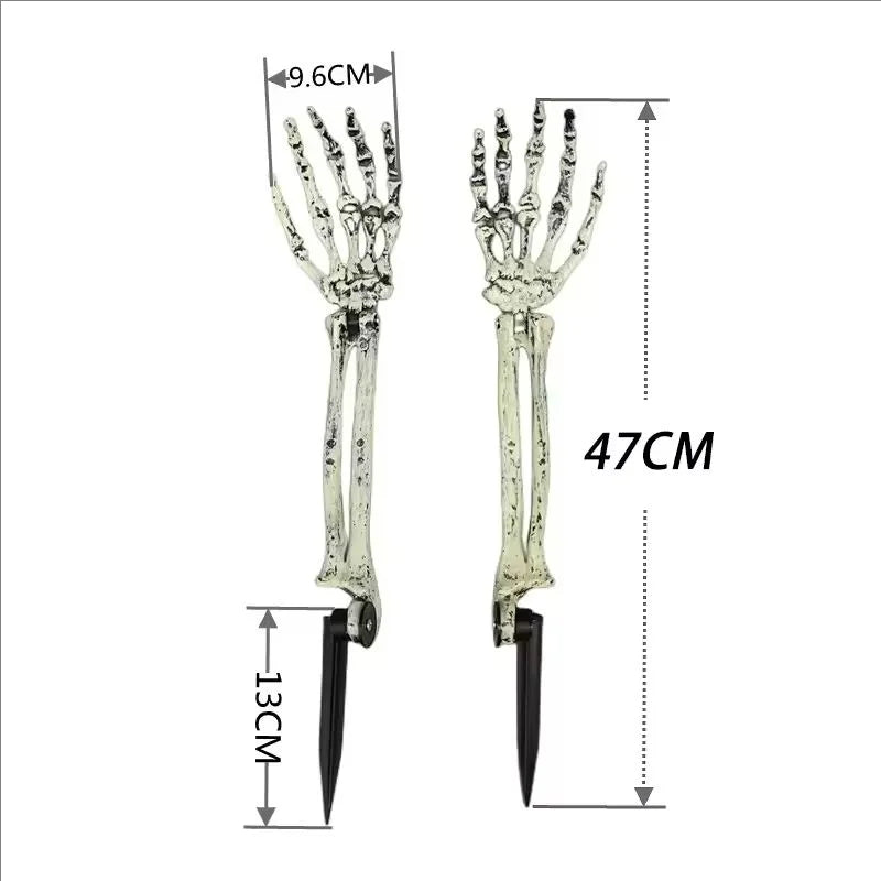 Two skeleton hand solar lights glowing in grass