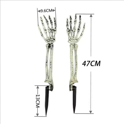 Two skeleton hand solar lights glowing in grass