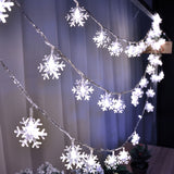 Snowflake LED light string lit warm white against a dark background