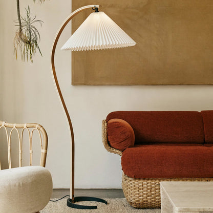 Caprani beechwood floor lamp with white linen shade in a living room