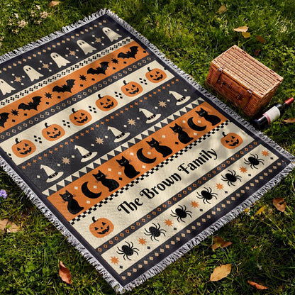 Personalized woven Halloween blanket laid outdoors with custom family name woven in