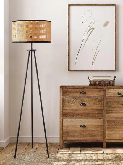 Rattan floor lamp glowing beside a sofa