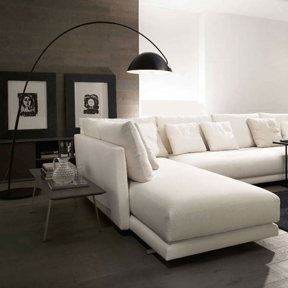 Verse arc floor lamp with black tapered metal stem in a living room setting