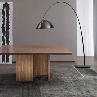 Verse arc floor lamp beside a reading chair, shade angled downward