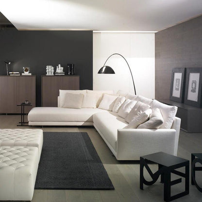 Verse arc floor lamp with black tapered metal stem in a living room setting