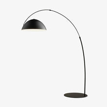 Verse arc floor lamp with black tapered metal stem in a living room setting
