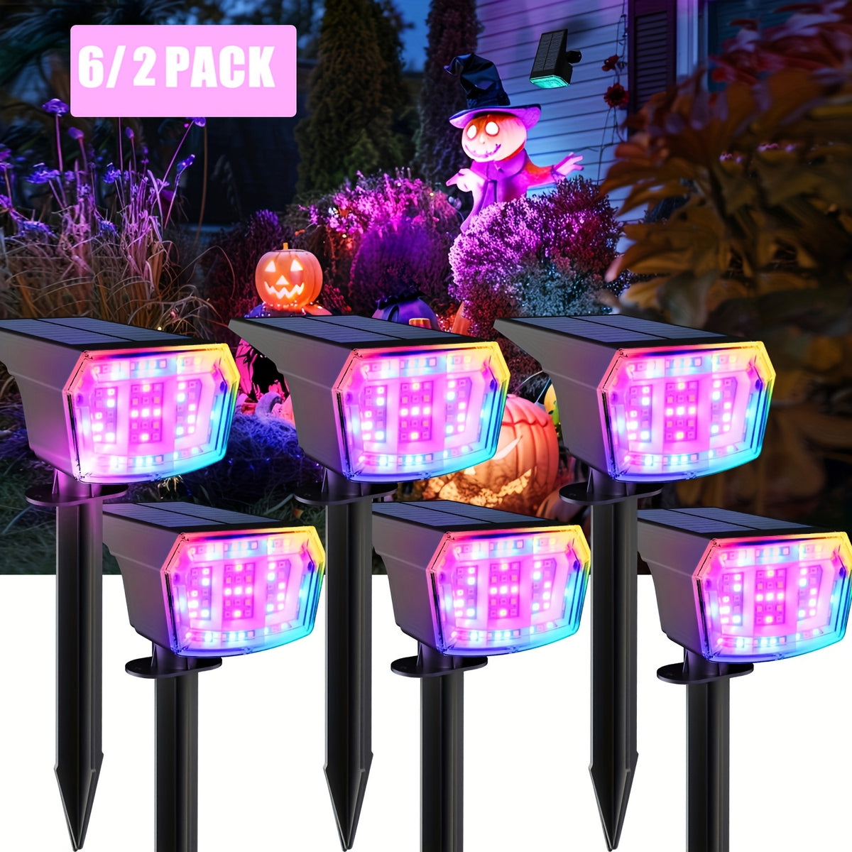 Solar landscape spotlight standing in garden bed with RGB colored glow at night