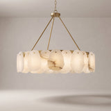 Alabaster chandelier with a brushed gold brass frame on a grey studio background