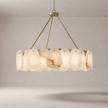 Alabaster chandelier with a brushed gold brass frame on a grey studio background