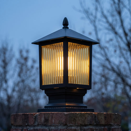 Ashwood post light glowing through ribbed amber glass at November dusk
