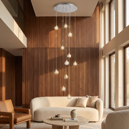 Astra crystal staircase chandelier in a warm double-height living room