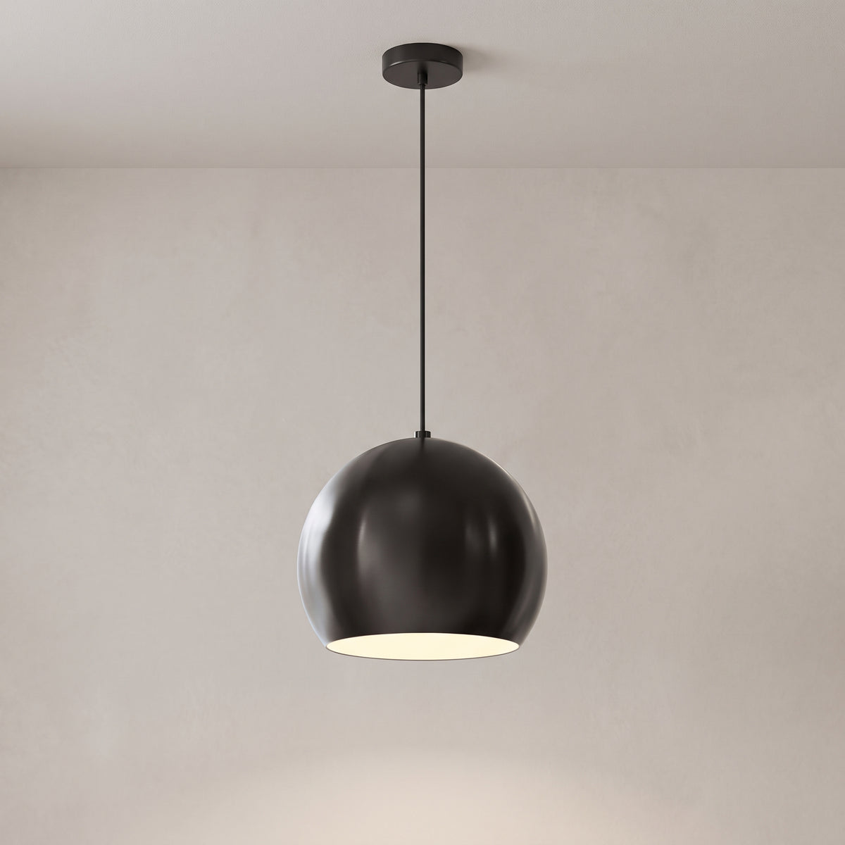 Vesper globe pendant light in matte black on a grey studio background
