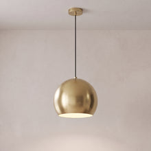 Vesper brass globe pendant light in brushed gold on a grey studio background