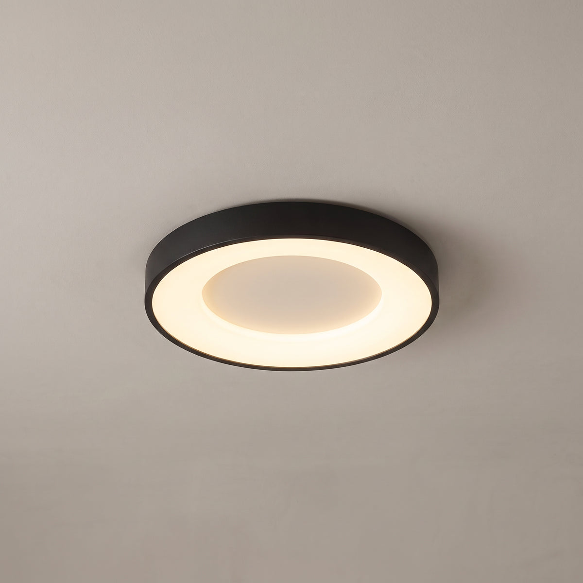 Alaric round flush mount ceiling light in matte black on a grey ceiling
