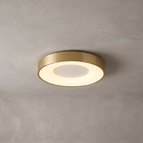 Alaric round flush mount ceiling light in brushed gold on a grey ceiling