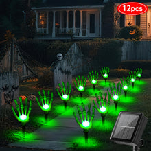 Twelve green solar ghost hand stake lights glowing along a garden path at night