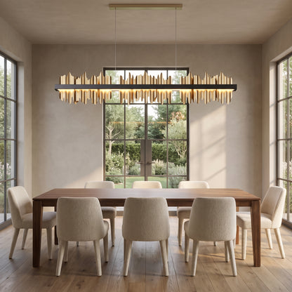 Cascade linear chandelier with polished gold plates above a long walnut dining table