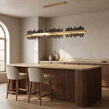 Cascade linear chandelier in jet black above a walnut kitchen island