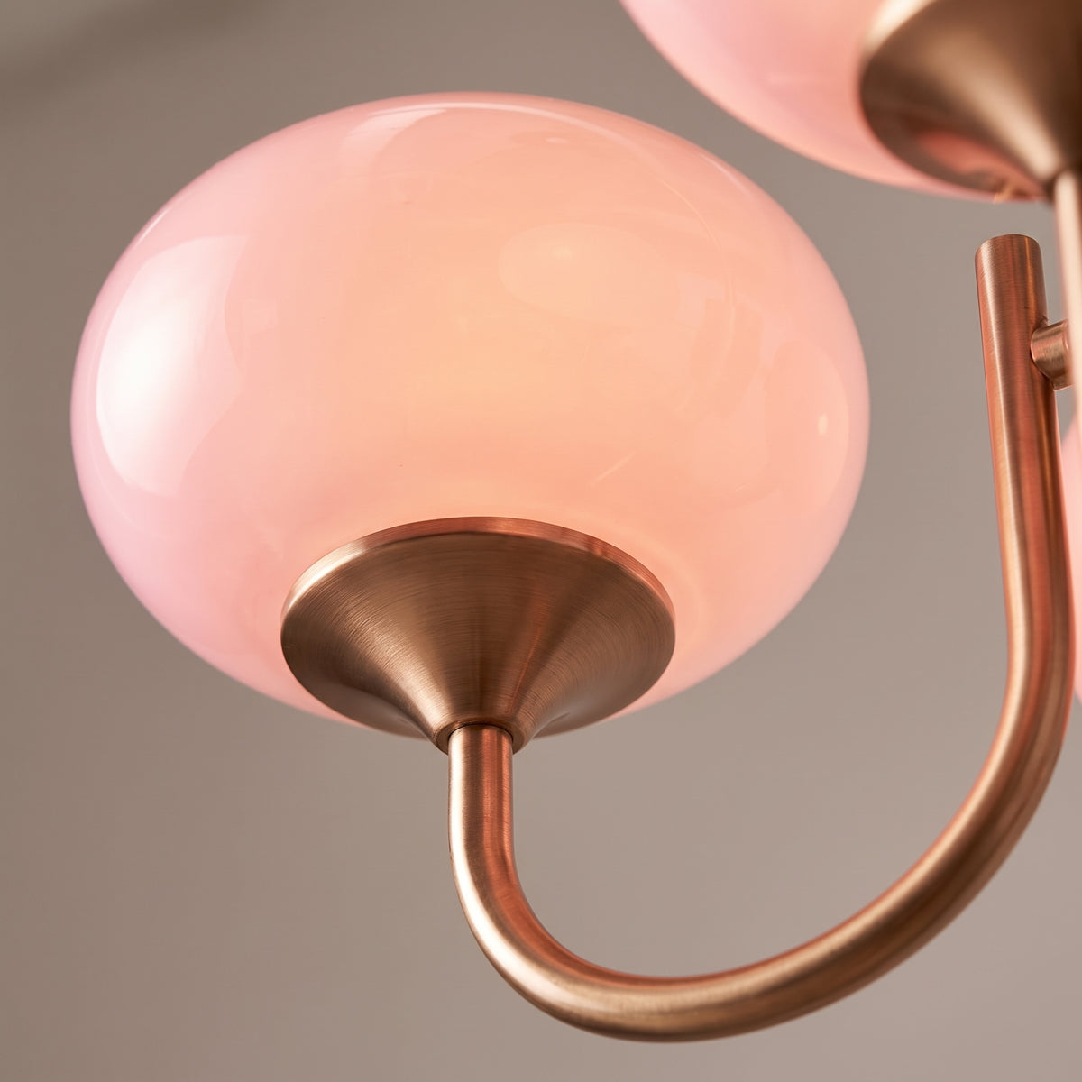 Close-up of the hand-sprayed glass shade and brushed copper arm of the Cloudlet chandelier