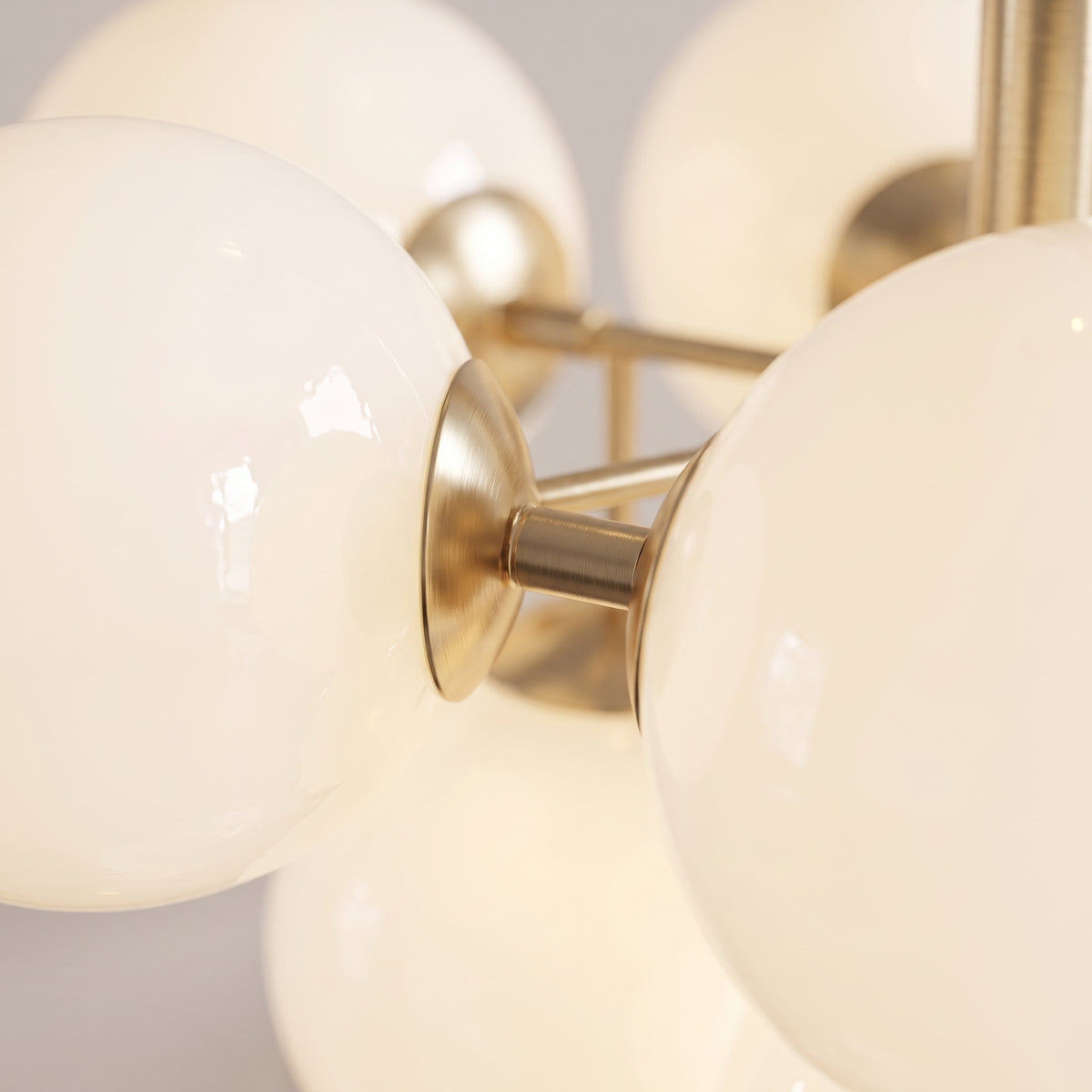 Close-up of the opal glass globes and brushed gold frame of the Solenne Pendant