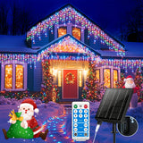 Solar icicle lights hanging in drops along a house roofline at night