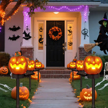 Solar pumpkin pathway lights glowing at night along a walkway
