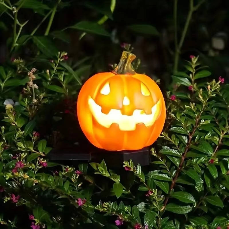 Multiple solar pumpkin lights illuminated at dusk