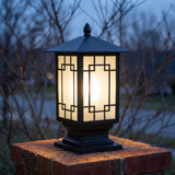 Elmwood post light glowing through lattice frosted glass at November dusk