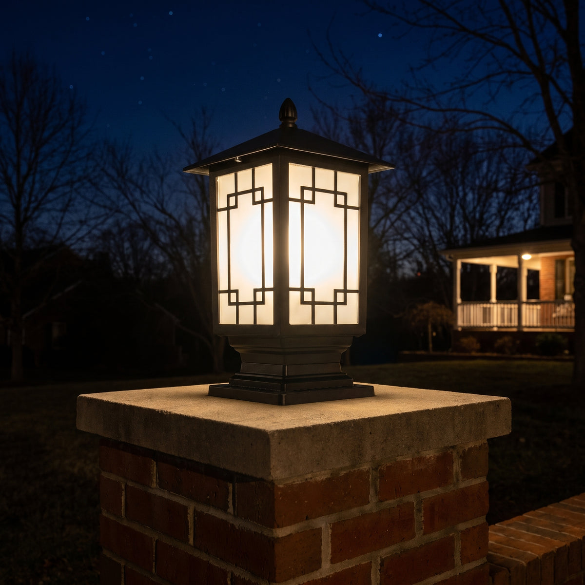 Elmwood post light glowing warm on a brick driveway pillar at night