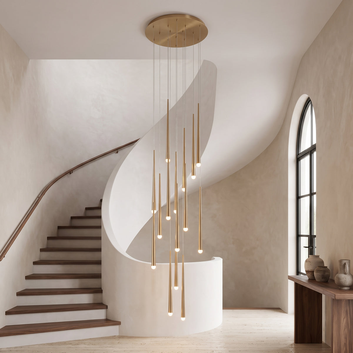 Aurelia cascading gold chandelier centered in an elegant curved stairwell