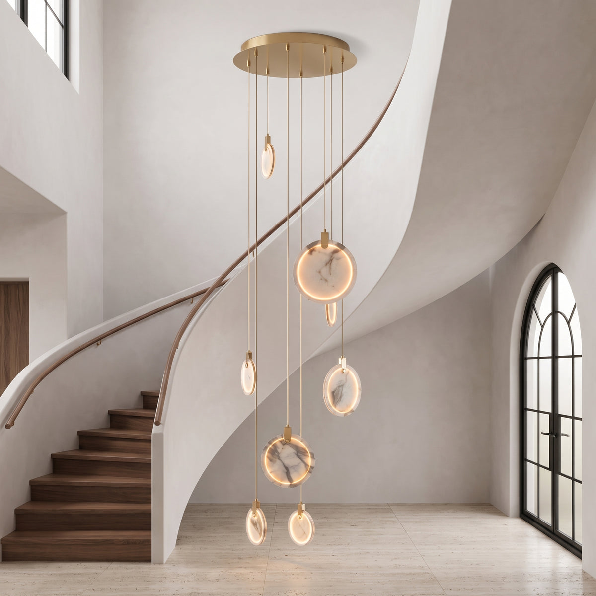 Marble cascading ring chandelier centered in an elegant curved stairwell