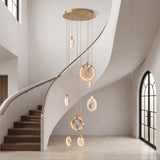 Marble cascading ring chandelier centered in an elegant curved stairwell