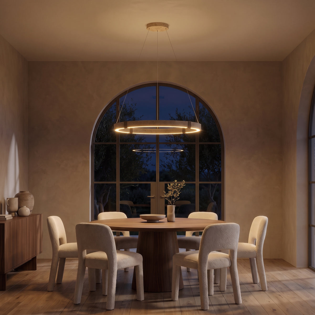 Torvi travertine ring chandelier at night — lights on