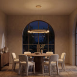 Torvi travertine ring chandelier at night — lights on