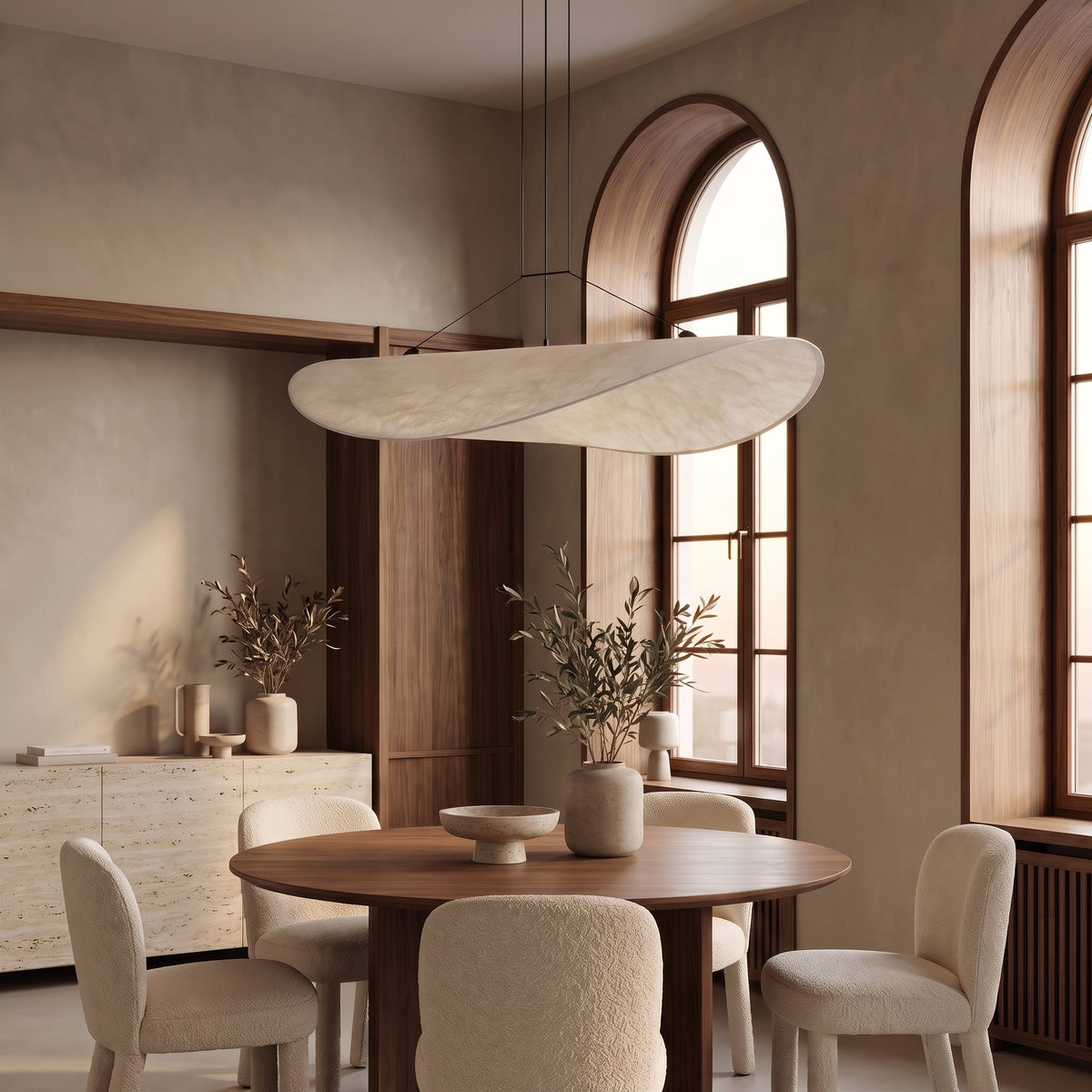 Kinu silk sail pendant light above a round walnut dining table in a bright daylight dining room