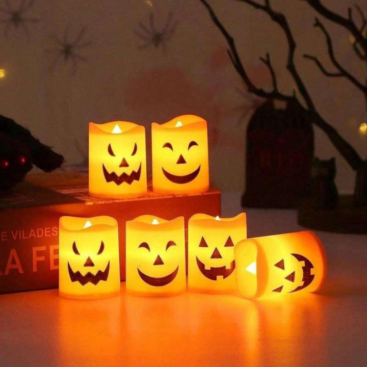 Pumpkin-shaped flameless LED candles glowing on a tabletop display