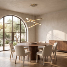 Gold ring chandelier with three rings above a round walnut dining table