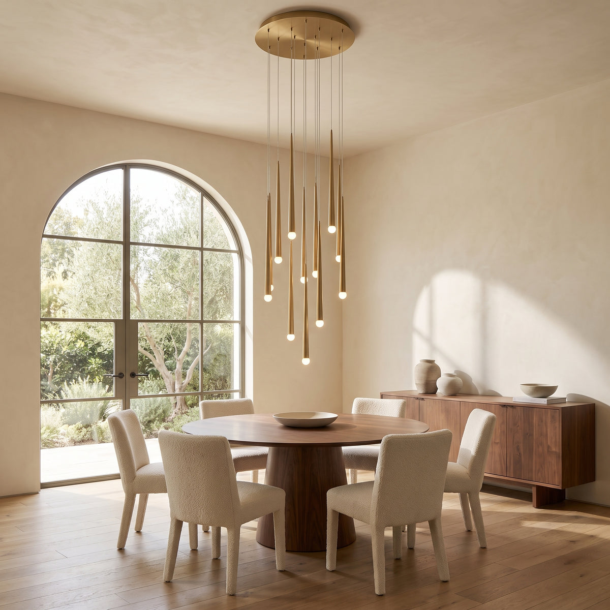 Cascading chandelier hanging above a round walnut dining table