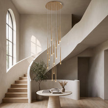 Cascading gold chandelier with 15 lights hanging in a double-height stairwell