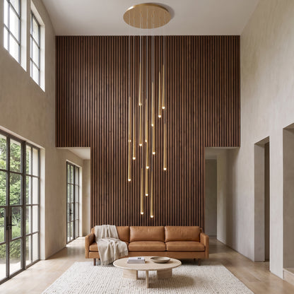 Cascading chandelier lit in a living room beside a walnut slat wall
