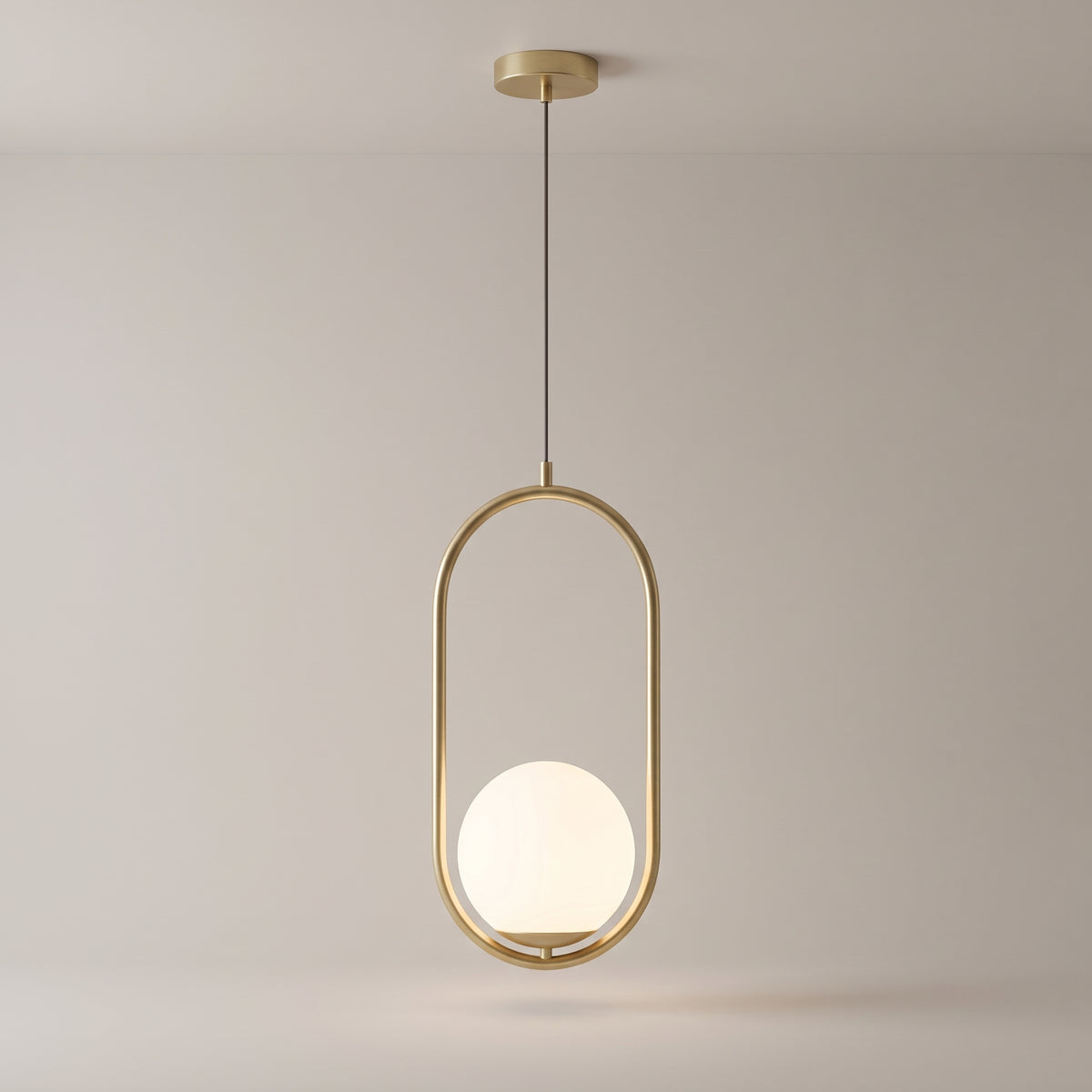 Opaline pendant in brushed gold on a grey studio background