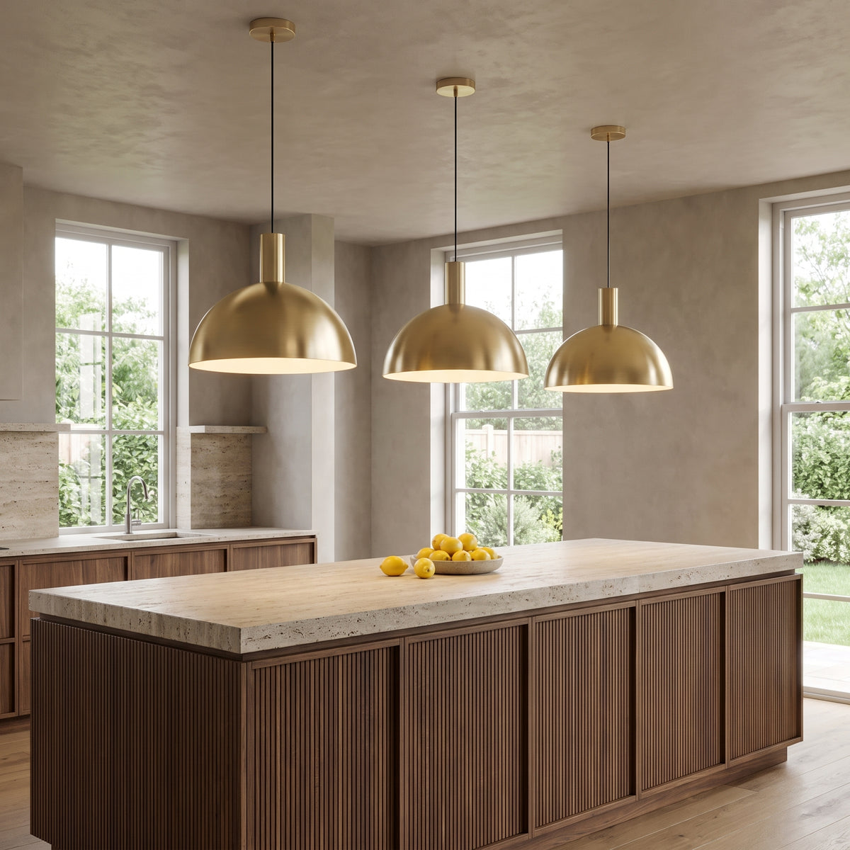 Three Isolde brass dome pendant lights in gold above a walnut kitchen island