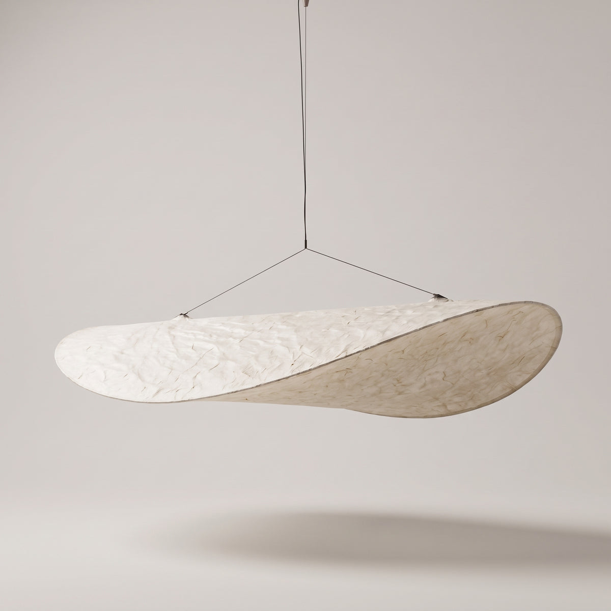 Kinu silk fabric pendant light on a warm grey studio background
