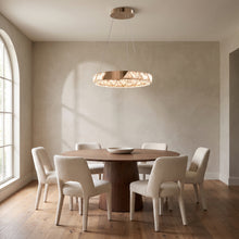 Noor rose gold crystal ring chandelier above a round walnut dining table